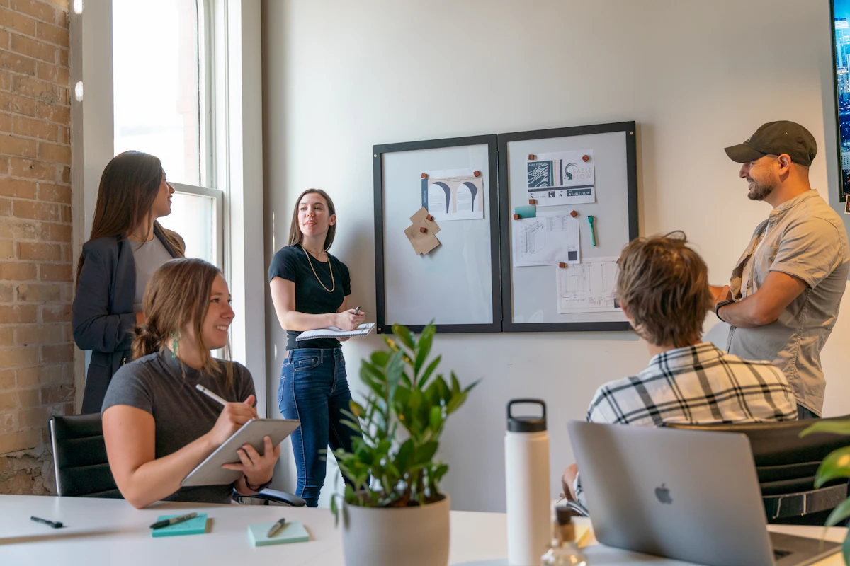 Colleagues gathered for a meeting in a sunlit office